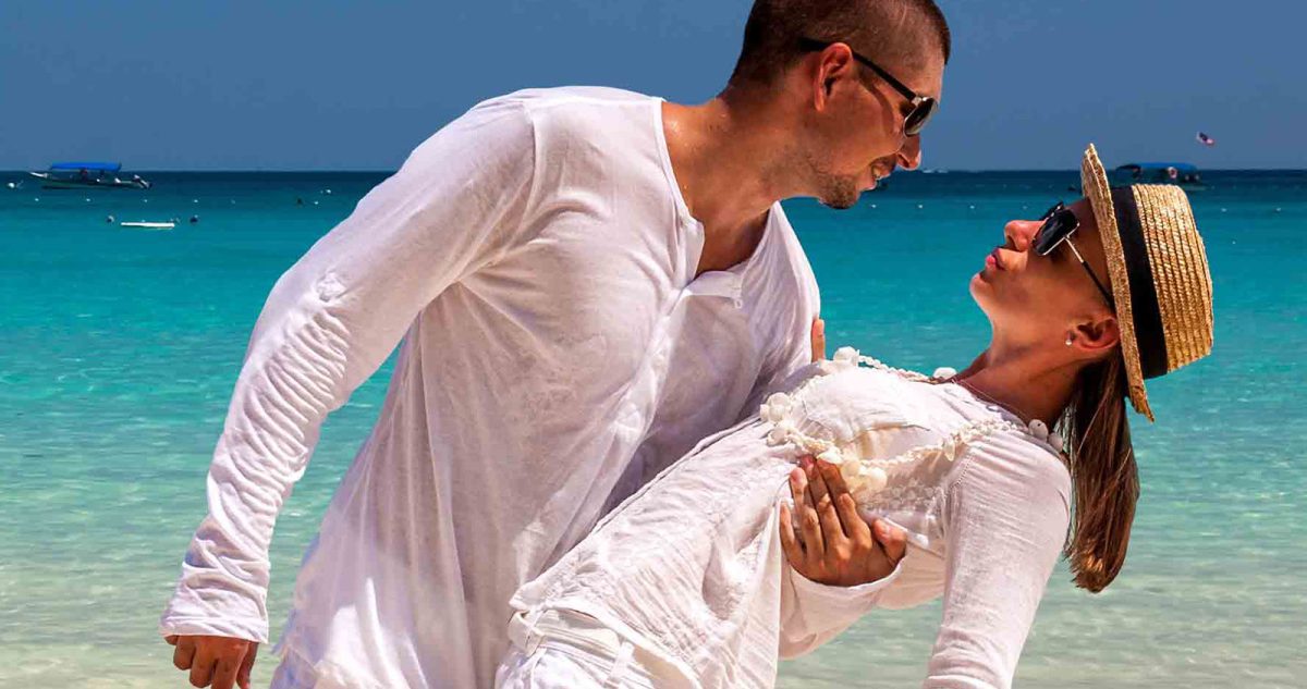 Man and a woman dancing intimately on Beach both in white clothes